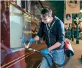  ?? NRM ?? The conservati­on team clean Queen Elizabeth II’s former carriage inside the National Railway Museum at York.