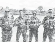  ?? ?? SIAP SIAGA: Henderi (dua kanan) bersama Ramlan (dua kiri), Azman (kanan) dan pegawai lain semasa ujian bot di Sungai Lawas kelmarin.