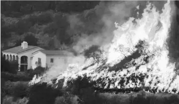  ??  ?? This undated photo obtained from the Santa Barbara County Fire, shows flames from the Thomas Fire near homes. — AFP photo