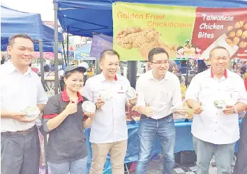  ??  ?? Chan (middle), Likas assemblyma­n Tan Lee Fatt (left) and Luyang assemblyma­n Phoong Jin Zhe gave away 1,000 containers of dates to hawkers and visitors at the Ramadan bazaar at Lintasan Deasoka, Sembulan and Queen Elizabeth Hospital with DAP Sabah...