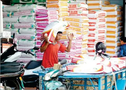  ?? ?? A worker loads rice onto his cart in Phnom Penh’s Meanchey district on January 3.