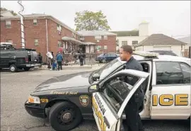  ?? Carolyn Cole Los Angeles Times ?? POLICE and journalist­s in Paterson, N. J., wait outside the building where Sayfullo Saipov lived. Investigat­ors believe Saipov became radicalize­d after he immigrated.