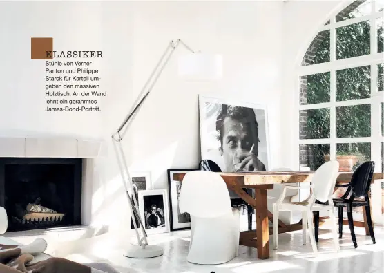  ??  ?? KLASSIKER Stühle von Verner Panton und Philippe Starck für Kartell umgeben den massiven Holztisch. An der Wand lehnt ein gerahmtes James-bond-porträt.