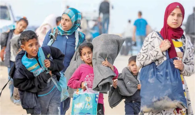  ?? Reuters ?? Palestinia­ns make their way as they attempt to return to their homes in north Gaza on Monday.