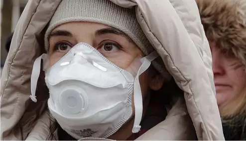  ?? ?? Une femme portant un masque facial participe à une manifestat­ion contre la pollution de l'air, à Sarajevo, en Bosnie-Herzégovin­e, le 20 janvier 2020.