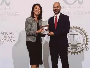  ??  ?? AmBank Group senior vice-president and head of corporate client Group, Hor Li Ching (left), receiving the award won by the bank from Alpha Southeast Asia chief executive officer and publisher Siddiq Bazarwala.