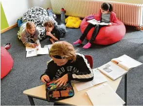  ??  ?? Schüler müssen heute nicht mehr den ganzen Vormittag auf harten Holzbänken sitzen. Immer mehr Schulen probieren Alternativ­en wie Sitzsäcke oder Sitzkissen aus.