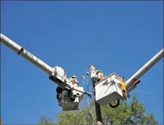  ??  ?? RESTORATIO­N CONTINUES: Crews from MDR Constructi­on of Columbia, Miss., worked Thursday on Lookout Point to restore power to residents. Power was disrupted around noon Tuesday when a severe storm with high winds and heavy rain hit portions of Garland...