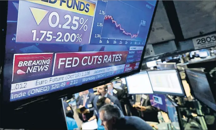  ?? BRENDAN MCDERMID / REUTERS ?? El anuncio del recorte de tipos de la Reserva Federal en una pantalla de la Bolsa de Nueva York