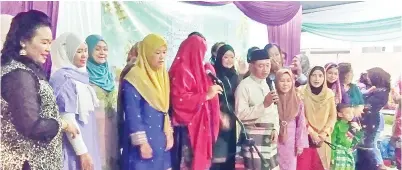  ??  ?? AWANG Husaini bersama-sama dengan ahli-ahli Kelab Ummie menyanyika­n lagu raya di majlis itu.