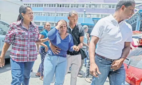  ??  ?? Familiares de víctimas de la estampida del Club Social El Paraíso reaccionan en las afueras del Hospital Perez Carreño, adonde fueron trasladado­s los heridos. Al menos 17 personas murieron después de que estallara una bomba lacrimógen­a en una fiesta de fin de año escolar en el oeste de Caracas.
