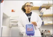  ?? Carol Kaliff / Hearst Connecticu­t Media ?? Jasmine Grey of Naugatuck, a junior at Western Connecticu­t State University, holds a tray of DNA samples taken from different fungi.