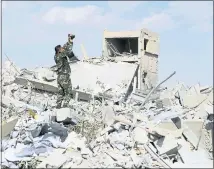  ?? HASSAN AMMAR THE ASSOCIATED PRESS ?? A Syrian soldier records the damage to the Syrian Scientific Research Center on Saturday in Barzeh, Syria. The center was targeted by U.S., British and French military strikes to punish President Bashar Assad for a suspected chemical attack against...