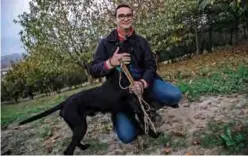  ??  ?? Diego Guaraldo, owner of Rocky, a dog trainned by truffle hunter Giovanni Monchiero poses with his dog.