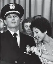  ?? R.L. Oliver
Los Angeles Times ?? AT THE LAPD, Daryl Gates was William H. Parker’s driver before eventually becoming chief himself in 1978. Above, his wife, Sima Gates, checks his badge.