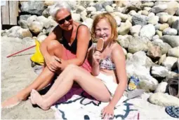  ??  ?? KOS MED IS: Linda Dalen og Helene (8) koser seg med en is på stranda. De mener at strand og sjø slår basseng.