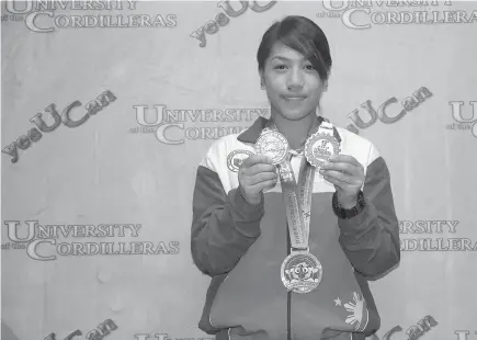  ?? SSB photo ?? CORDILLERA PRIDE. Wushu athlete Divine Masadao Wally in this file photo shows her several medals she won in internatio­nal competitio­n. Wally bagged the country’s fifth bronze medal in the 18th Asian Games in Jakarta, Indonesia.