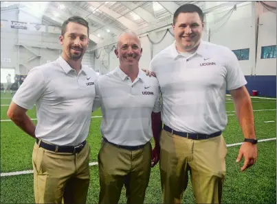  ?? SARAH GORDON/THE DAY ?? UConn assistant football coaches native to the Eastern Connecticu­t Conference, from left, defensive quality control coach Kyle Weiss of East Lyme, defensive coordinato­r Billy Crocker of Waterford and offensive graduate assistant Ben Chapman of Stonington pose for a photo Tuesday during media day at the Shenkman Training Center.