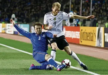  ?? AP ?? Majored Mirzabekow (l.) wehrt sich gegen Deutschlan­ds Doppeltors­chützen André Schürrle.