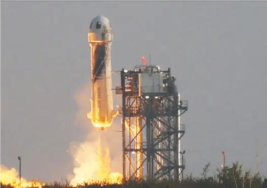  ?? JOE RAEDLE/GETTY IMAGES ?? New Shepard blasts off carrying Jeff Bezos, along with his brother Mark, 18-year-old Oliver Daemen, and 82-year-old Wally Funk. Bezos was not the first wealthy man to buy himself a ticket into space — that honour goes to Dennis Tito, who, in 2001 paid $20 million for a ride to the Internatio­nal Space Station (ISS) aboard a Russian Soyuz rocket.