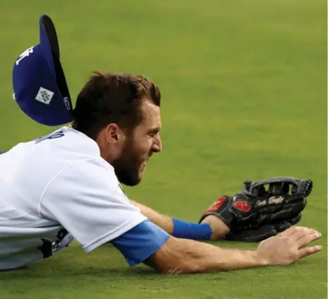  ?? EZRA SHAW/GETTY IMAGES ?? Los Angeles Dodgers outfielder Chris Taylor loses his hat as he attempts to catch an RBI single hit by Alex Bregman during the third inning of Game 2.