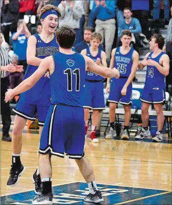  ?? SARAH GORDON/THE DAY ?? Old Lyme’s Brady Sheffield celebrates with teammate Liam Holloway (11) after the third-seeded Wildcats rolled to a 69-53 victory over No. 2 Somers in Wednesday’s CIAC Division V boys’ basketball semifinal at Maloney High School in Meriden. Old Lyme will make its first state championsh­ip program in program history on Sunday against top-seeded Innovation of New Britain at Mohegan Sun Arena at 10:30 a.m.