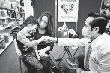  ?? NEW YORK TIMES NICOLE CRAINE/THE ?? Lauren Rymer holds her son, Jack, 5, after he received a COVID-19 vaccine Nov. 15 in Lawrencevi­lle, Georgia.