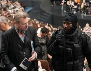  ??  ?? Implicatio­n. Christophe­r Nolan (à g.) et John David Washington, sur le tournage de « Tenet ». Le réalisateu­r filme lui-même les scènes d’action avec ses chefs opérateurs.
