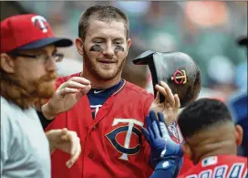  ??  ?? Robbie Grossman gets congratula­tions from his Twins teammates after he scored in the fifth inning on Bobby Wilson’s single to left, breaking a scoreless tie. In the next inning, Grossman’s RBI single to left put Minnesota ahead 2-0. It was one of eight Minnesota hits; Grossman finished the day 2 for 3.