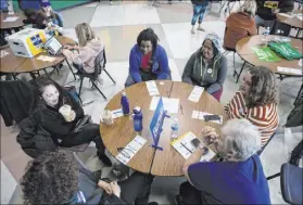  ?? Ellen Schmidt Las Vegas Review-Journal @ellenkschm­idt_ ?? Supporters of candidate Bernie Sanders chat at their table before the Nevada caucus on Feb. 22 at Palo Verde High School.