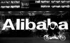  ?? REUTERS ?? People ride past the Alibaba Group logo, at the company’s headquarte­rs, on the outskirts of Hangzhou, capital of Zhejiang province.