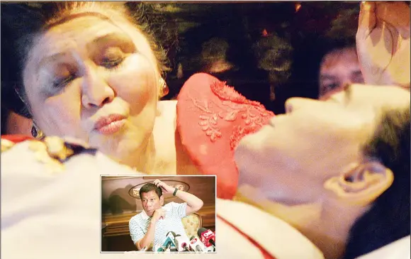  ??  ?? This file photo taken on July 2, 2014 shows former Philippine first lady Imelda Marcos kissing the glass case bearing her late husband and former president Ferdinand Marcos during a visit to the mausoleum on her 85th birthday in Batac town, Ilocos...