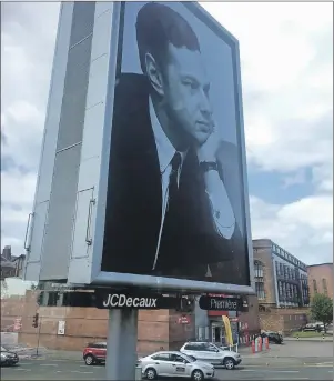  ?? CP PHOTO ?? In this photo taken this week, cars drive past a billboard showing the late Beatles manager Britain Epstein, created by artist Jeremy Deller, in Liverpool, England. The work is part of a festival in the city celebratin­g the 50th anniversar­y of the...