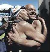  ?? Francine Orr Los Angeles Times ?? MAURINE KORNFELD, left, greets pal Errol Graham at the U.S. Masters Swimming Spring National Championsh­ip in Mesa, Ariz., in April.