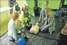  ?? 01_B31emerg06 ?? Evelyn Thomson, an Arran west coast first responder demonstrat­es CPR to the Peebles family.