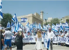  ?? (Tovah Lazaroff) ?? PARTICIPAN­TS IN the annual Hebron march show the flag, with the Tomb of the Patriarchs in the background yesterday.