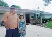  ?? MARIA LORENZINO/STAFF PHOTOGRAPH­ER ?? When the frozen sausage hit the roof of the Deerfield Beach home, “it was like a bomb went off,” said Jenny Adair, here with her husband, Travis.