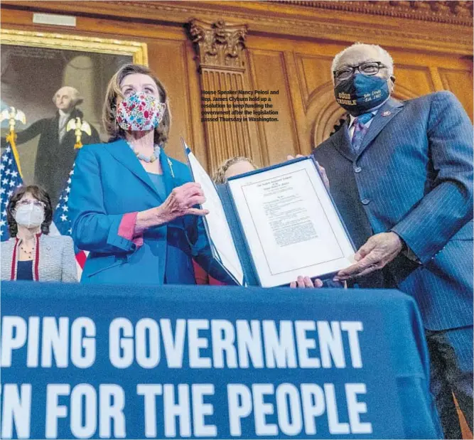  ?? ?? House Speaker Nancy Pelosi and Rep. James Clyburn hold up a resolution to keep funding the government after the legislatio­n passed Thursday in Washington.