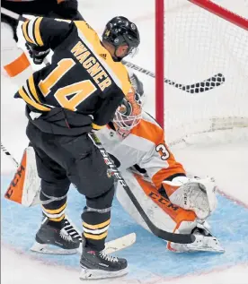  ?? CHRIS CHRISTO / BOSTON HERALD FILE ?? Bruins forward Chris Wagner scores past Philadelph­ia Flyers goaltender Brian Elliott on Sept. 23.