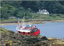  ??  ?? The boat stranded on the rocks.