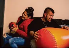  ?? Stephen Lam/The Chronicle ?? Claudia Arevalos and partner Ricardo Mendoza laugh together as they struggle to inflate a soccer ball and boxing column.