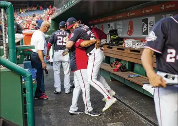  ?? PABLO MARTINEZ MONSIVAIS / AP ?? Bryce Harper is hugged by Nationals manager Dave Martinez before a 2018 game. “The first thing you want to do when you see the guys … you want to give them a big hug, a fist-bump, high-five,” Martinez said.