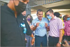  ??  ?? Puerto Rico Gov. Pedro Pierluisi (center) attends a mass vaccinatio­n campaign against covid-19 at the Maria Simmons Elementary School. Pierluisi has resisted tighter restrictio­ns, saying another lockdown would be too extreme and that things will keep improving and the island could achieve herd immunity by August. “The solution is vaccinatio­n.”