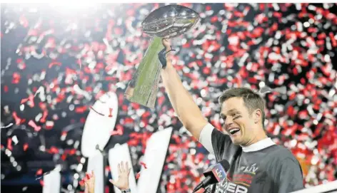  ?? FOTO: LIEBENBERG/AP ?? Tom Brady stemmt im Konfettire­gen im Raymond-James-Stadium in Tampa die Vince-Lombardi-Trophäe für den Gewinn des Super Bowls in die Luft.