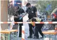 ?? DANIEL KARMANN, EPA ?? Police officers examine the scene of a suicide bombing Monday in Ansbach, Germany.