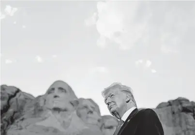  ?? ANNA MONEYMAKER/THE NEW YORK TIMES ?? President Donald Trump watches a military plane flyover at Mount Rushmore in July.