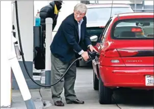  ?? SULLIVAN/GETTY IMAGES/AFP JUSTIN ?? A customer puts petrol into his car at a Shell gas station in San Francisco, California.