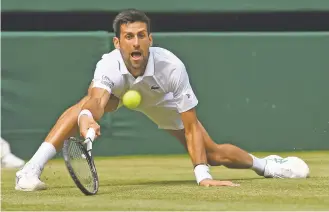  ?? ANDY RAIN/ASSOCIATED PRESS ?? Serbia's Novak Djokovic returns a shot to Spain's Roberto Bautista Agut on Friday at Wimbledon. Djokovic won in four sets.