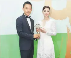  ??  ?? Chinese actress Yin Tao, right, and actor Zhang Yi pose with their Best Actress and Best Actor trophies.