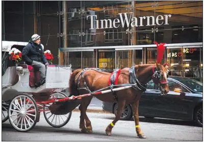  ?? AP ?? A horse-drawn carriage passes the Time Warner Inc. center in New York in this 2016 file photo. A ruling is expected today in the government’s antitrust lawsuit to block AT&amp;T’s proposed $85.4 billion acquisitio­n of Time Warner.